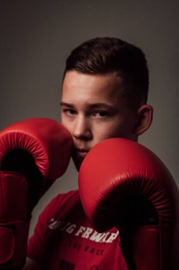 Genç bir boksör, karanlık arka planda boks eğitimi alıyor. Agresif bir spor. Yüksek kalite fotoğraf