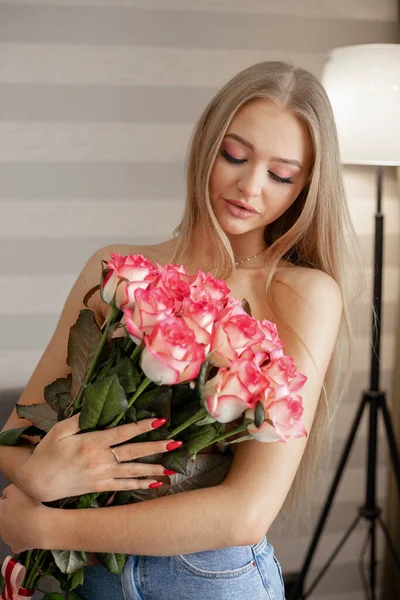 Beautiful woman with a large bouquet of roses. Attractive sexy woman. High quality photo
