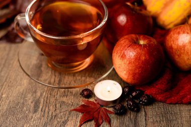 Çayın ve sonbahar meyvelerinin yanında yanan mum. Sonbahar Kompozisyonu. Yüksek kalite fotoğraf