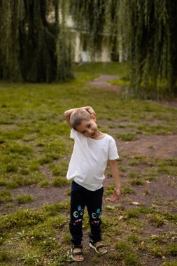 Bir okul çocuğu akşamleyin parkta yürür. Tatilde. Mutlu bir çocukluk. Yüksek kalite fotoğraf
