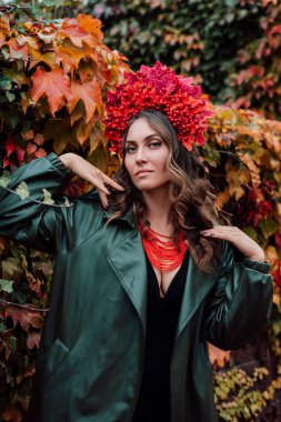 Kafasında sonbahar çelengi olan güzel bir Ukraynalı kadın. Sonbahar akşamı. Toplanıyoruz. Yüksek kalite fotoğraf