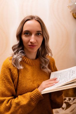 Kanepede kitabı olan bir kadın. Bir kadın kitap okuyor. Evde öğreniyorum. Yüksek kalite fotoğraf