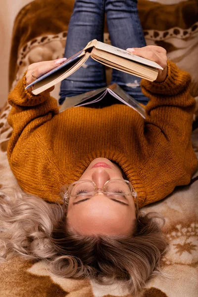 Woman with a book on the sofa. A woman reads a book. Learning at home. High quality photo