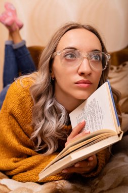 Evdeki kanepede kitap okuyan bir kadın. Merkez ofis. Uzaktan Öğrenme. Yüksek kalite fotoğraf