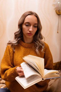 Evdeki kanepede kitap okuyan bir kadın. Merkez ofis. Uzaktan Öğrenme. Yüksek kalite fotoğraf