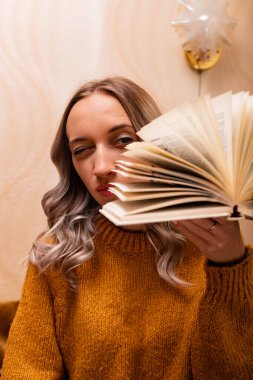 Evdeki kanepede kitap okuyan bir kadın. Merkez ofis. Uzaktan Öğrenme. Yüksek kalite fotoğraf