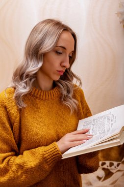 Evdeki kanepede kitap okuyan bir kadın. Merkez ofis. Uzaktan Öğrenme. Yüksek kalite fotoğraf