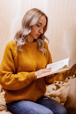 Evdeki kanepede kitap okuyan bir kadın. Merkez ofis. Uzaktan Öğrenme. Yüksek kalite fotoğraf