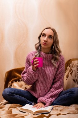 Kanepede oturan kitap ve çaylı kadın. Retro tarzı. Bilgi Günü 'nde. Yüksek kalite fotoğraf