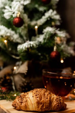 Noel ağacının yanında bir fincan kruvasanla çay. Yılbaşı gecesi evde ailemle olacağım. Yüksek kalite fotoğraf