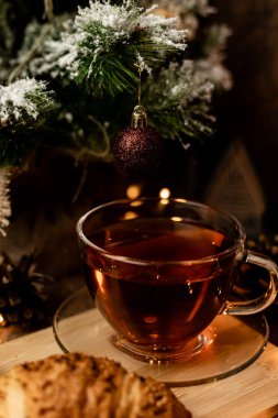 Noel ağacının yanında bir fincan kruvasanla çay. Yılbaşı gecesi evde ailemle olacağım. Yüksek kalite fotoğraf