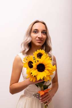 Bir buket ayçiçeğiyle gelinlik giymiş gelin. Güzel kadın. Çiçekçilik. Yüksek kalite fotoğraf