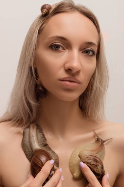 Yüzünde salyangoz olan güzel bir kadın. Kozmetoloji prosedürleri, cilt gençleştirme. Yüksek kalite fotoğraf