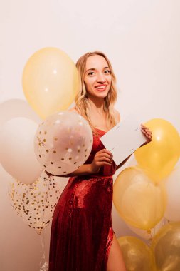 Kırmızı uzun elbiseli, balonlu bir kadın. Doğum günü kutlaması. Yüksek kalite fotoğraf