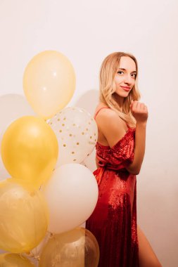 Kırmızı uzun elbiseli, balonlu bir kadın. Doğum günü kutlaması. Yüksek kalite fotoğraf