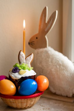 Yanmış mumlu Paskalya pastası. Masadaki sepetteki Paskalya renkli yumurtalar. Yüksek kalite fotoğraf