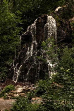 Mountain waterfall. Waterfall in the mountains in summer. Rocks. High quality photo clipart