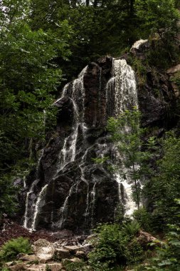 Mountain waterfall. Waterfall in the mountains in summer. Rocks. High quality photo clipart