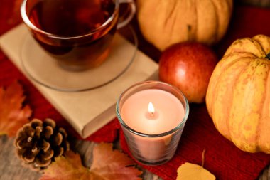 Sonbahar kompozisyonu, çay, balkabağı, masada mum. Evde sonbahar konforu. Yüksek kalite fotoğraf