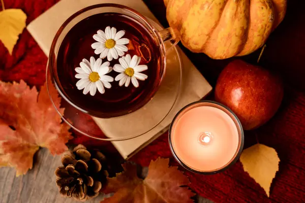 Sonbahar kompozisyonu, çay, balkabağı, masada mum. Evde sonbahar konforu. Yüksek kalite fotoğraf