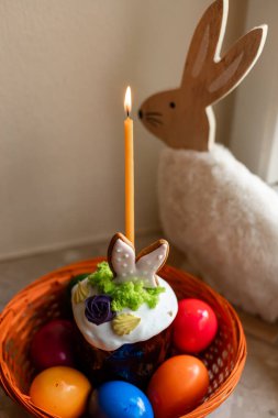 Yanmış mumlu Paskalya pastası. Masadaki sepetteki Paskalya renkli yumurtalar. Yüksek kalite fotoğraf