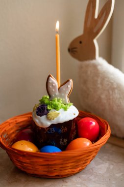 Yanmış mumlu Paskalya pastası. Masadaki sepetteki Paskalya renkli yumurtalar. Yüksek kalite fotoğraf