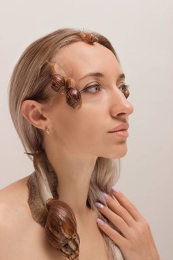 Yüzünde salyangozlar olan güzel genç bir kadın. Yenilenme prosedürleri. Yüksek kalite fotoğraf