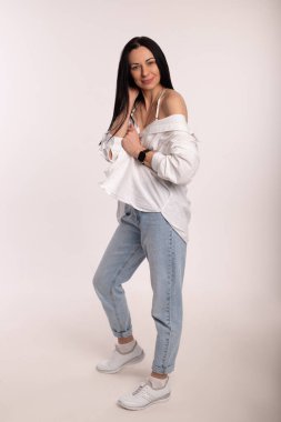 Beyaz arka planda kot pantolonlu güzel bir kadın. İş kadınıyım. Yüksek kalite fotoğraf