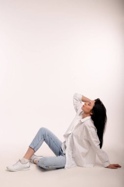 Beyaz arka planda kot pantolonlu güzel bir kadın. İş kadınıyım. Yüksek kalite fotoğraf