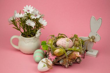 Paskalya yumurtaları, tavşancık ve pembe arka planda çiçekler. Paskalya Kompozisyonu. Yüksek kalite fotoğraf