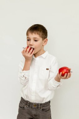 Bir çocuk arka planda elma yiyor. Elmalı bir çocuğun portresi. Yüksek kalite fotoğraf