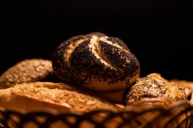 Haşhaş tohumlu taze pişmiş çörek. Çeşitli taze hamur işleri. Masanın üzerinde hasır bir sepetin içinde ekmek. Yüksek kalite fotoğraf