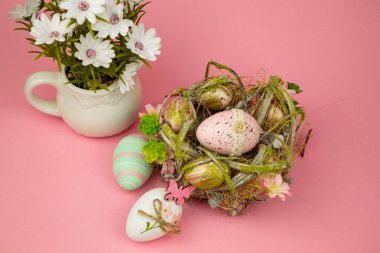 Pembe arka planda Paskalya renkli yumurtalar. Yuvadaki ve Çiçeklerdeki Paskalya Kompozisyonu Yumurtaları. Yüksek kalite fotoğraf