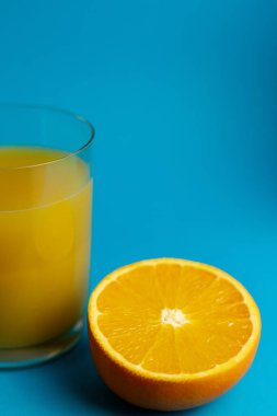 Taze kesilmiş portakal ve bir bardak taze sıkılmış meyve suyu. Yüksek kalite fotoğraf