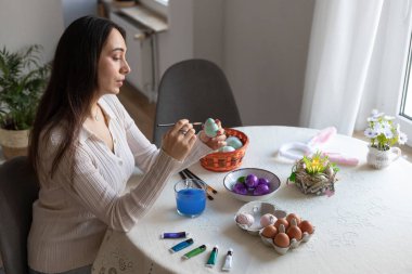 Paskalya yumurtalarını boyayan güzel bir kadın. Paskalya yumurtalarını elinde tutan bir kadın. Yüksek kalite fotoğraf