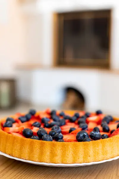 Çilekli ve yaban mersinli turta. Ev yapımı tatlı. Ev yapımı hamur işleri. Şöminenin yanında çay içiyorum. Yüksek kalite fotoğraf