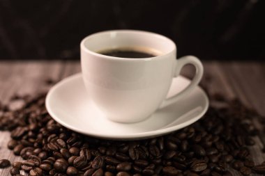 Kahverengi arka planda bir fincan kahve ve kahve çekirdeği. Koyu kahve. Yüksek kalite fotoğraf