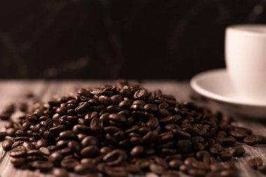 Kahverengi arka planda bir fincan kahve ve kahve çekirdeği. Koyu kahve. Yüksek kalite fotoğraf