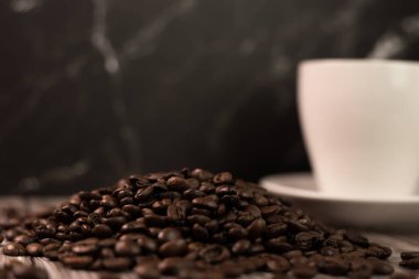 Arka planda bir fincan kahve ve kahve çekirdeği. Kavrulmuş kahve çekirdeği. Yüksek kalite fotoğraf