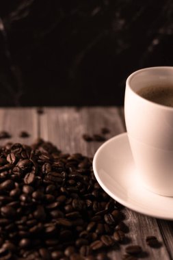 Kahverengi arka planda bir fincan kahve ve kahve çekirdeği. Koyu kahve. Yüksek kalite fotoğraf