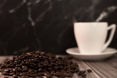 Arka planda bir fincan kahve ve kahve çekirdeği. Kavrulmuş kahve çekirdeği. Yüksek kalite fotoğraf