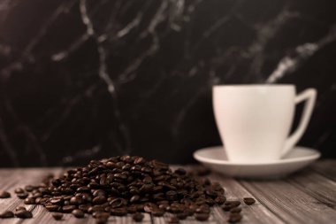 Arka planda bir fincan kahve ve kahve çekirdeği. Kavrulmuş kahve çekirdeği. Yüksek kalite fotoğraf