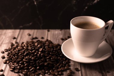 Arka planda bir fincan kahve ve kahve çekirdeği. Kavrulmuş kahve çekirdeği. Yüksek kalite fotoğraf