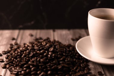 Arka planda bir fincan kahve ve kahve çekirdeği. Kavrulmuş kahve çekirdeği. Yüksek kalite fotoğraf