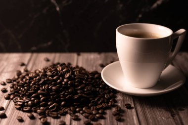 Kahverengi arka planda bir fincan kahve ve kahve çekirdeği. Koyu kahve. Yüksek kalite fotoğraf