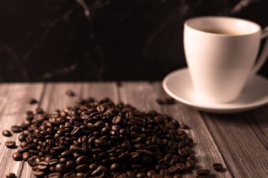 Arka planda bir fincan kahve ve kahve çekirdeği. Kavrulmuş kahve çekirdeği. Yüksek kalite fotoğraf