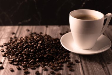 Arka planda bir fincan kahve ve kahve çekirdeği. Kavrulmuş kahve çekirdeği. Yüksek kalite fotoğraf