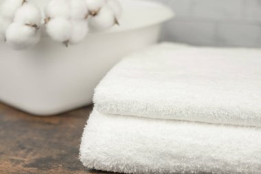 İki beyaz havlu ver. Beyaz bir leğende pamuk çiçekleri. Doğal kumaşlar. Yüksek kalite fotoğraf