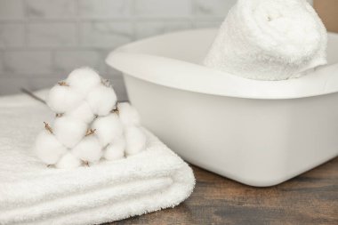 Beyaz plastik leğen. Terry havluları ve kurutulmuş pamuk çiçekleri. Yıkama. Yüksek kalite fotoğraf