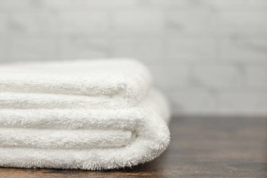 Ahşap bir yüzeyde düzgünce katlanmış beyaz havlular. Yüksek kalite fotoğraf